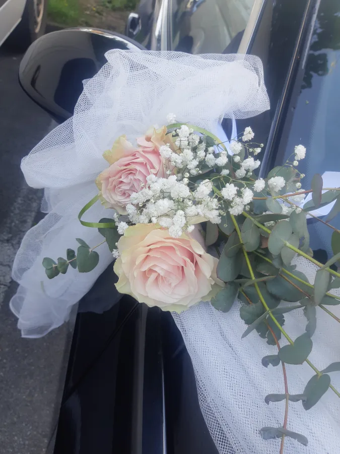 Dekoracija za auto mladenaca s rozim ružama.