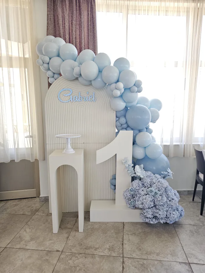 Bijela dekoracija s plavim cvijećem za prvi rođendan djeteta Gabriela.