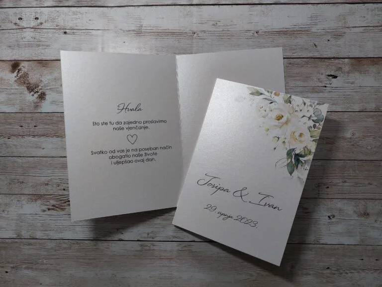 Zahvalnica za vjenčanje kao čestitka s imenima mladenaca, datumom, mogućom fotografijom para i citatom za goste. U desnom kutu je ukrašeno bijelim cvijećem s zelenim listovima.