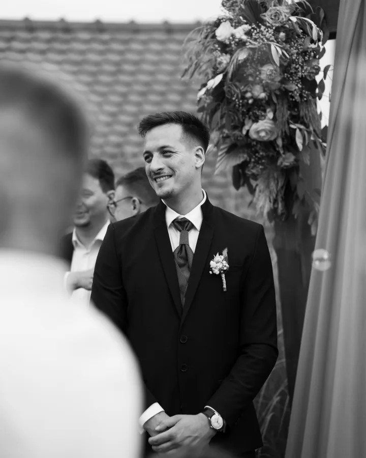 Mladoženja se smije čekajući mladu pred oltarom.