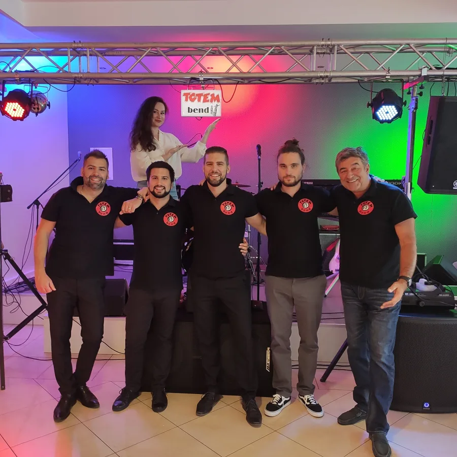 Članovi benda poziraju ispred pozornice za fotografiju prije nastupa u sali za vjenčanje.