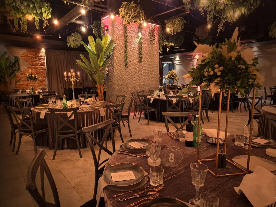 Dekorirana Infinity sala za vjenčanje Zagreb u smeđim tonovima s buketima cvijeća i svijećnjacima na sredini okruglih stolova.