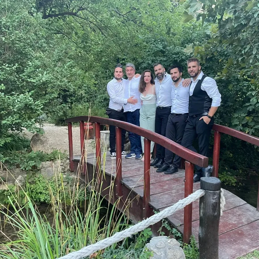 Članovi bend naslonjeni na mali drveni mostić.