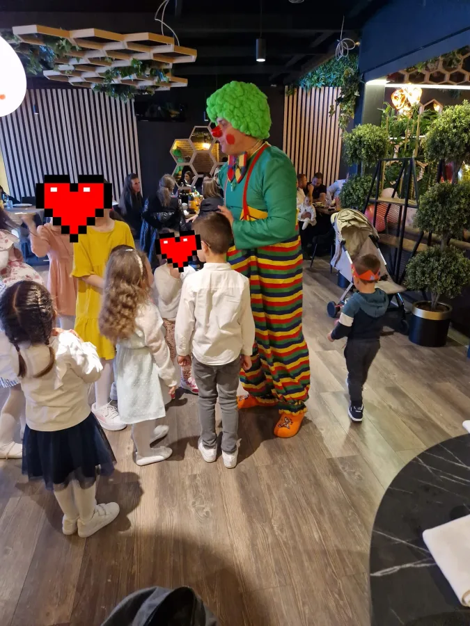 Djeca slušaju klauna kako govori za vrijeme proslave.