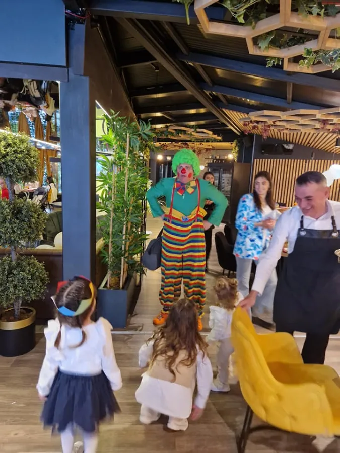 Djeca gledaju u klauna u restoranu.