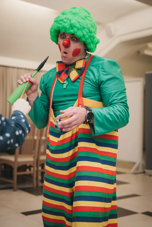 Klaun drži pumpu za balone u rukama.