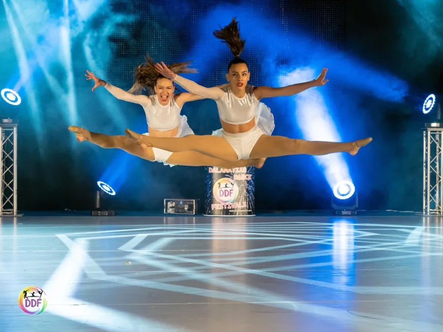 Plesačice na pozornici plešu obasjane reflektorima.