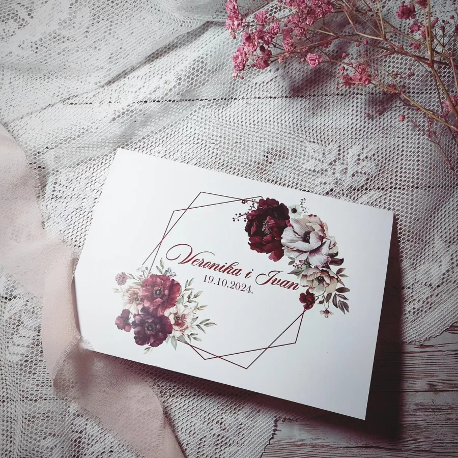 Zahvalnica za vjenčanje kao čestitka s imenima mladenaca, datumom vjenčanja i dizajnom crvenkasto-ružičastog cvijeća.
