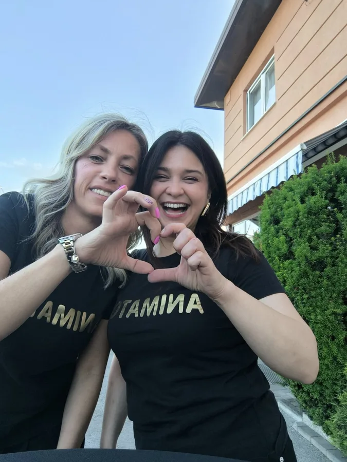 Dvije dječje animatorice rade srce rukom i smiju se.