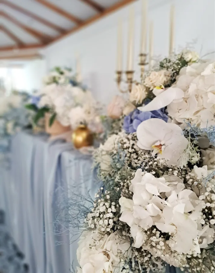 Bijelo cvijeće na stolu za mladence u sali za vjenčanje.