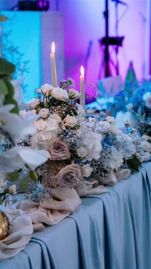 Stol mladenaca dekoriran cvijećem u sali za vjenčanje.