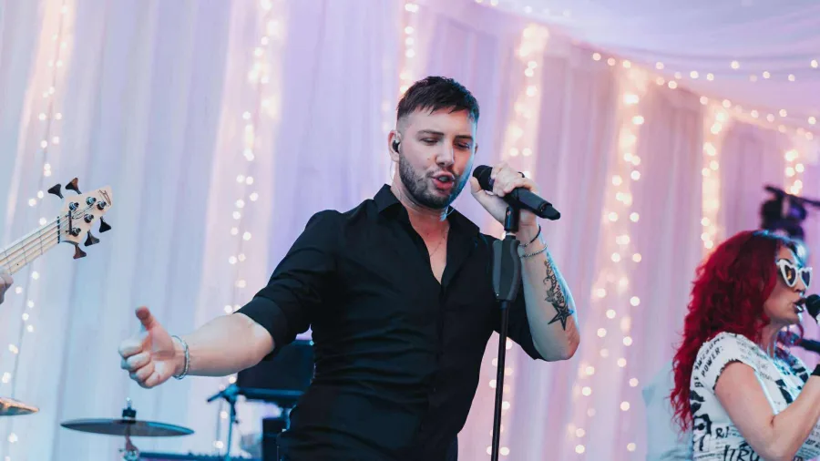 Alen Bičević pjeva s mikrofonom na vjenčanju.