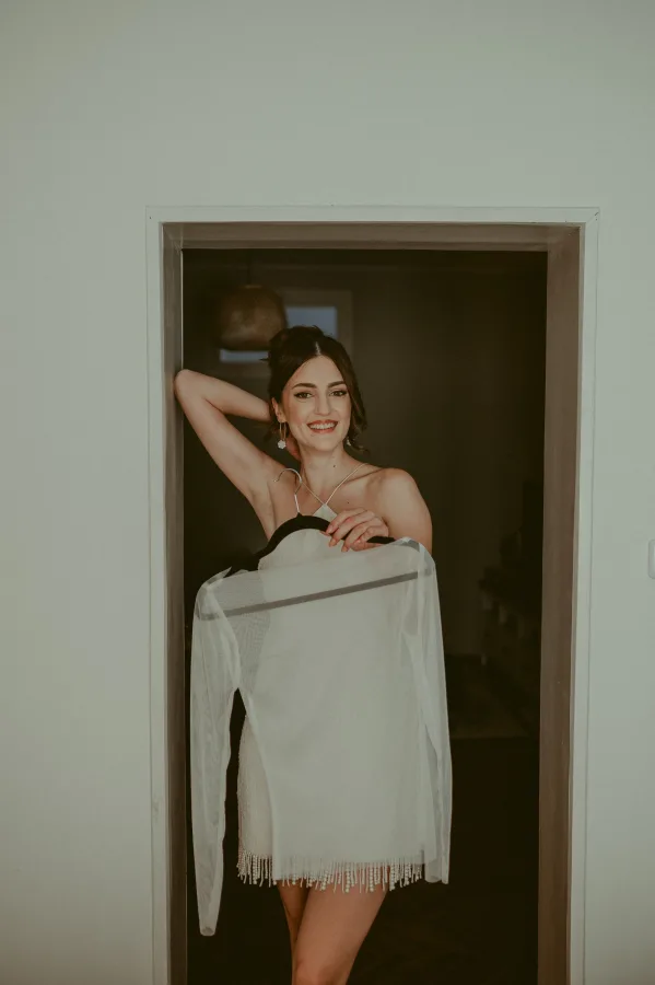 Mladenka oslonjena o dovratnik se smije.