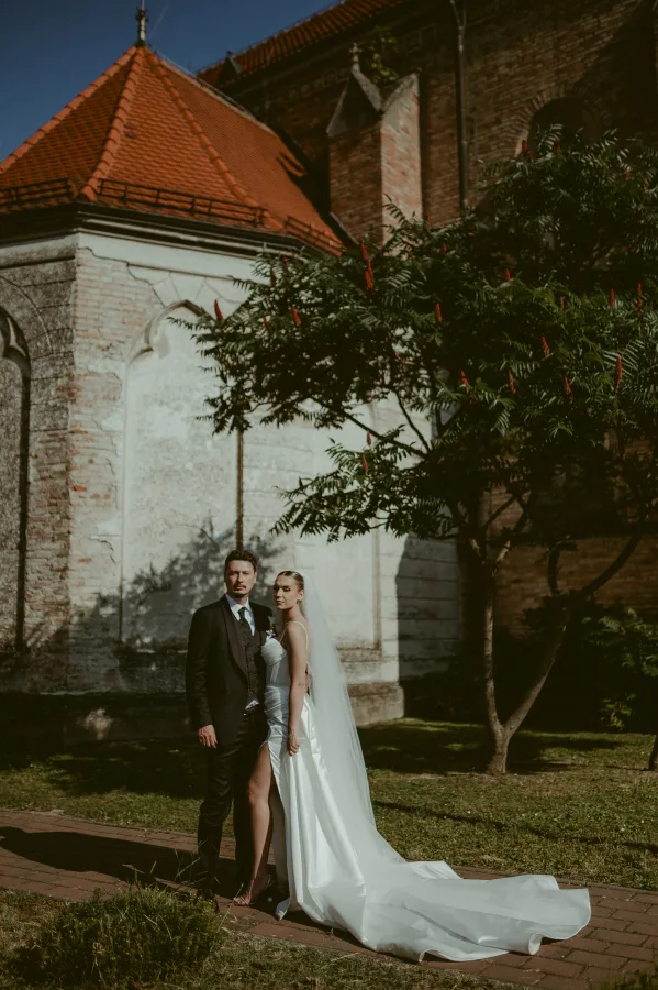 Mladenci ispred dvorišta crkve.
