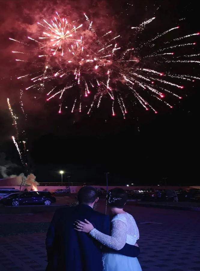 Mladenci gledaju vtromet ispred sale za vjenčanje.