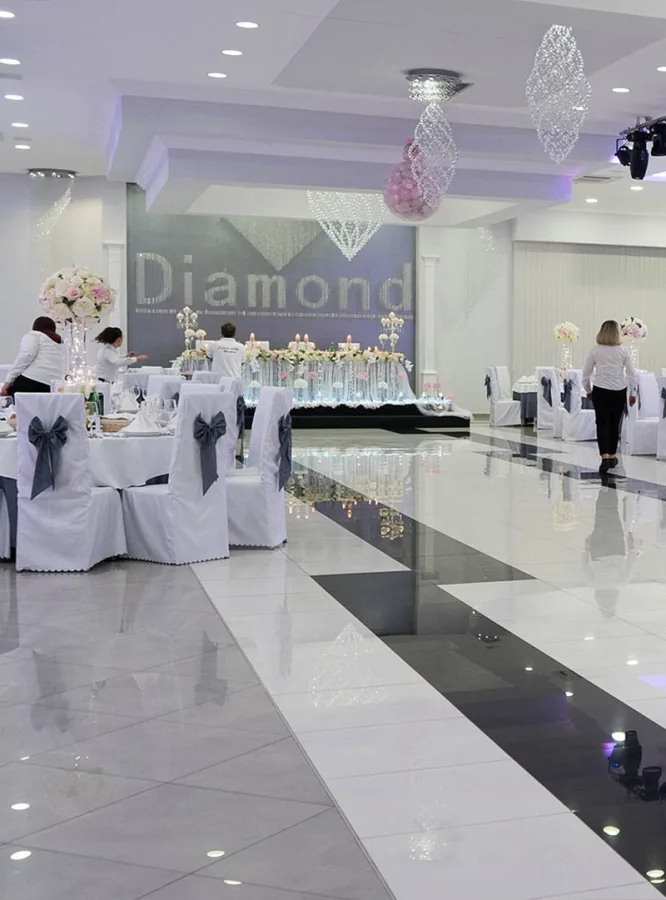 Konobari u sali za vjenčanje postavljaju stolove prije ulaska mladenaca i njihovih uzvanika.