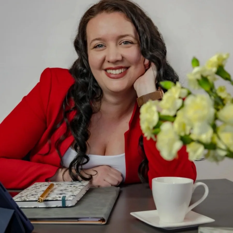 Nasmijana žena u crvenom sakou.