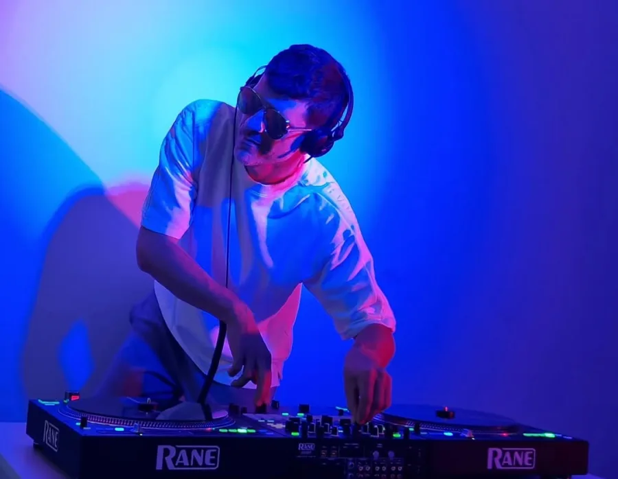 Dj za misketom pod neonskom rasvjetom.