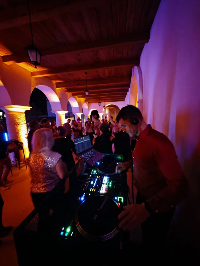 DJ za misketom na vjenčanju dok gosti plešu.