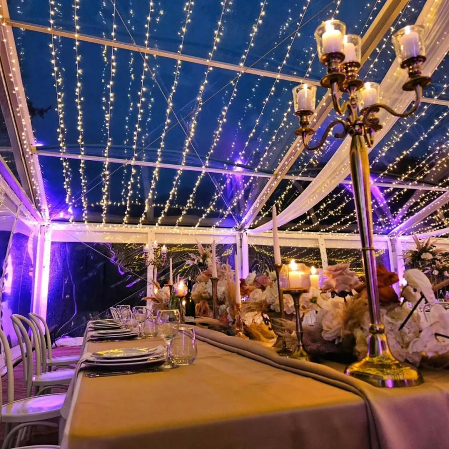 Stol mladenaca pod šatorom i lampicama.