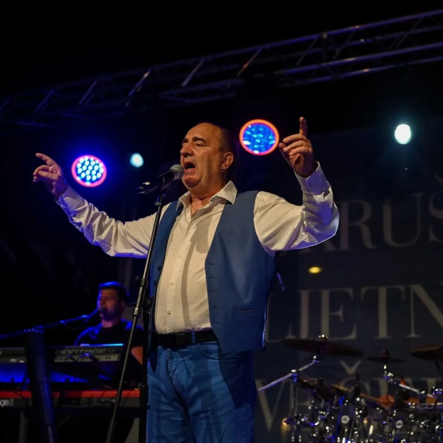 Mladen Grdović na pozornici osvijetljen reflektorima.