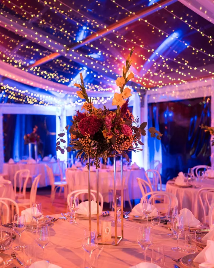 Dekoracija stola za vjenčanje s cvijećem u šatoru za vjenčanje.