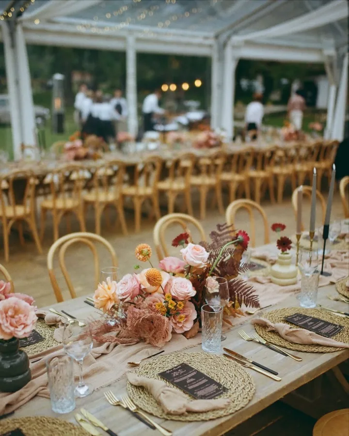 Stolovi za vjenčanje dekorirani u boho stilu pod šatorom.