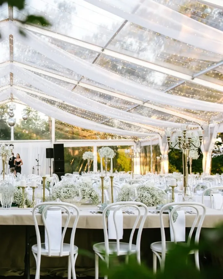 Dekorirani bijeli stol mladenaca pod šatorom Heritage Event Venue.