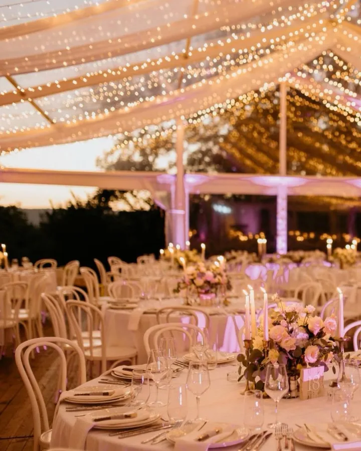 Dekorirani okrugli bijeli stolovi za vjenčanje u sali za vjenčanje Heritage Event Venue.