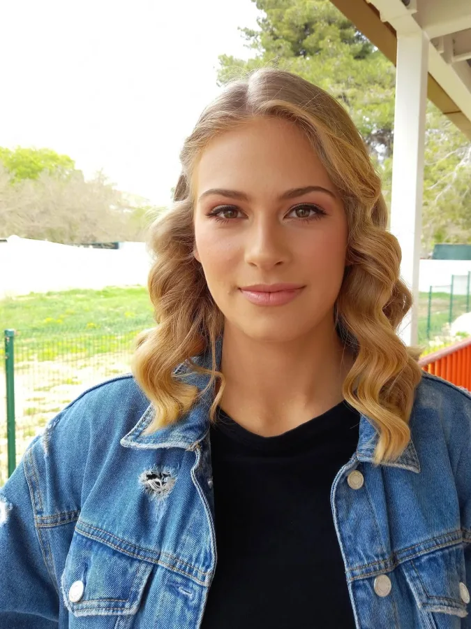 Žena valovite plave kose prirodno, decentno našminkana.