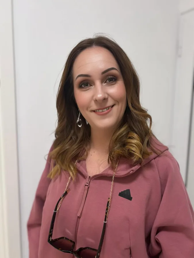 Starija žena valovite smeđe kose prirodno našminkana.