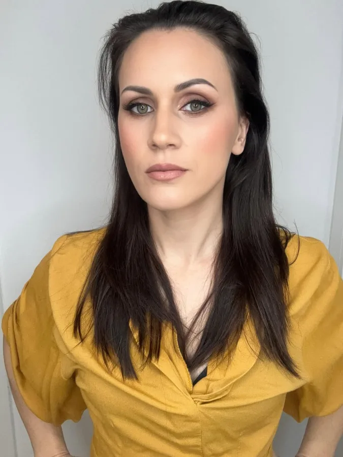 Starija žena crne kose prirodne šminke sa sjenilom na očima.