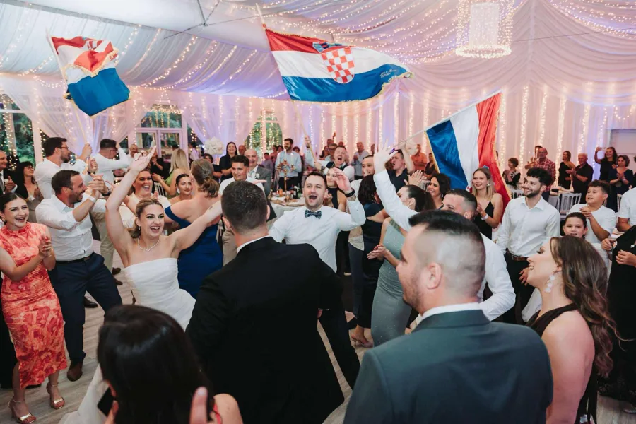 Bend Grupa joy pjeva na vjenčanju dok uzvanici vjenčanja i mladenci plešu na plesnom podiju.