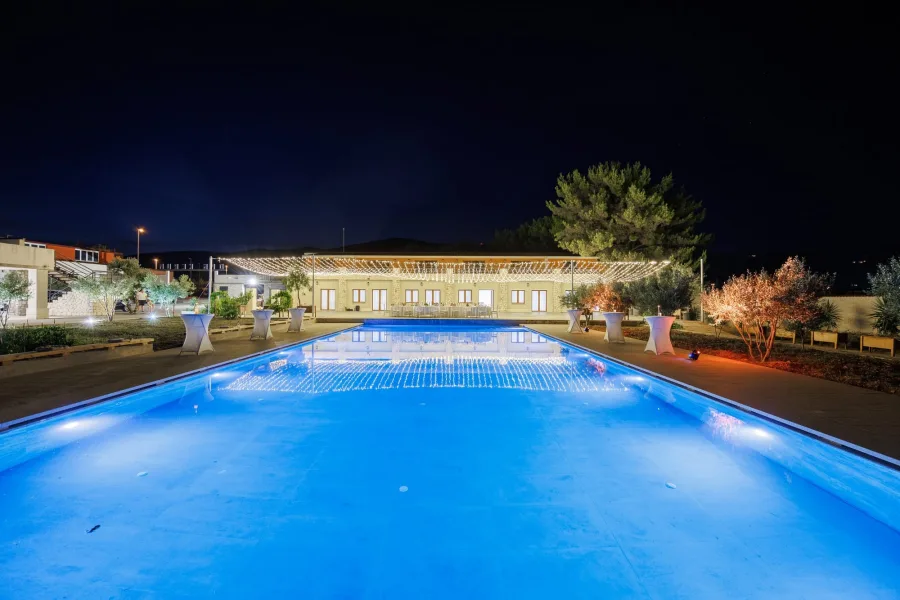 Vjenčanje uz bazen na otvorenom pod lampicama.