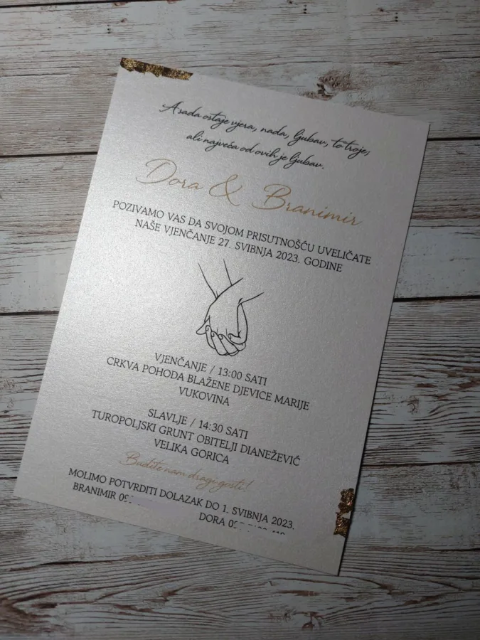 Pozivnica za vjenčanje na bijelkastom sjajnom papiru s ilustracijom dvije ruke koje se drže.