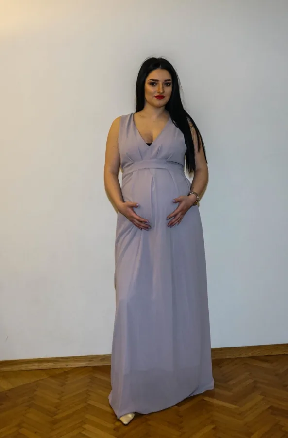 Trudnica u svečanoj ljubičastoj haljini.