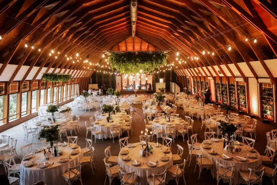 Unutrašnjost sale za vjenčanja Imanje Marincel s okruglim stolovima.