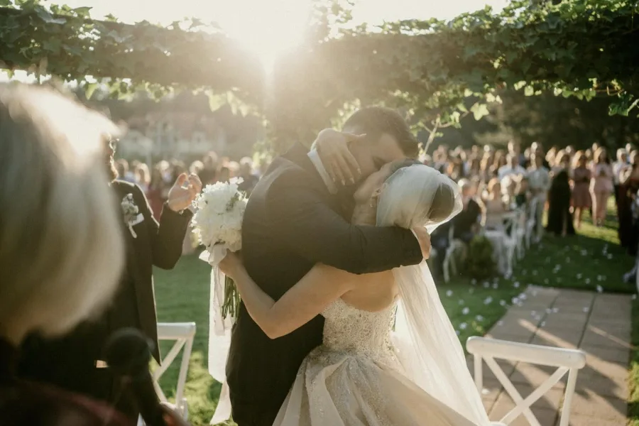 Mladenci se ljube nakon obreda vjenčanja na otvorenom.