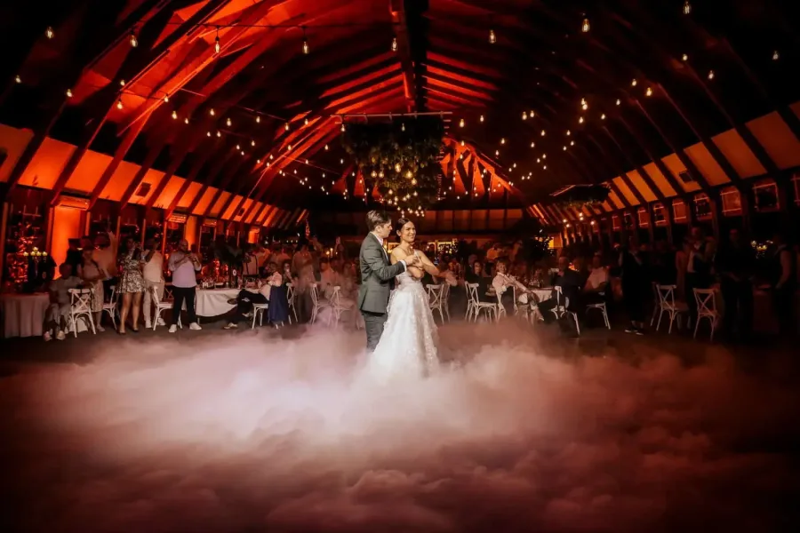 Mladenci plešu prvi ples u magli na vjenčanju.