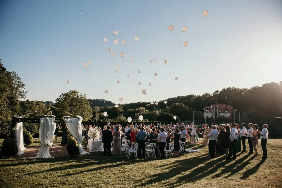 Gosti vjenčanja puštaju bijele balone nakon ceremonije.