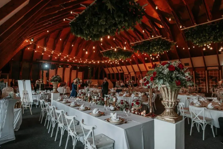 Dekorirana sala za vjenčanje sa stolovima i bijelim stolnjacima.