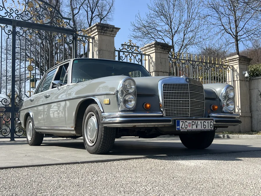 Elegantni sivi Mercedes 280SE oldtimer uslikan s bočne strane, luksuzan auto za vjenčanja.