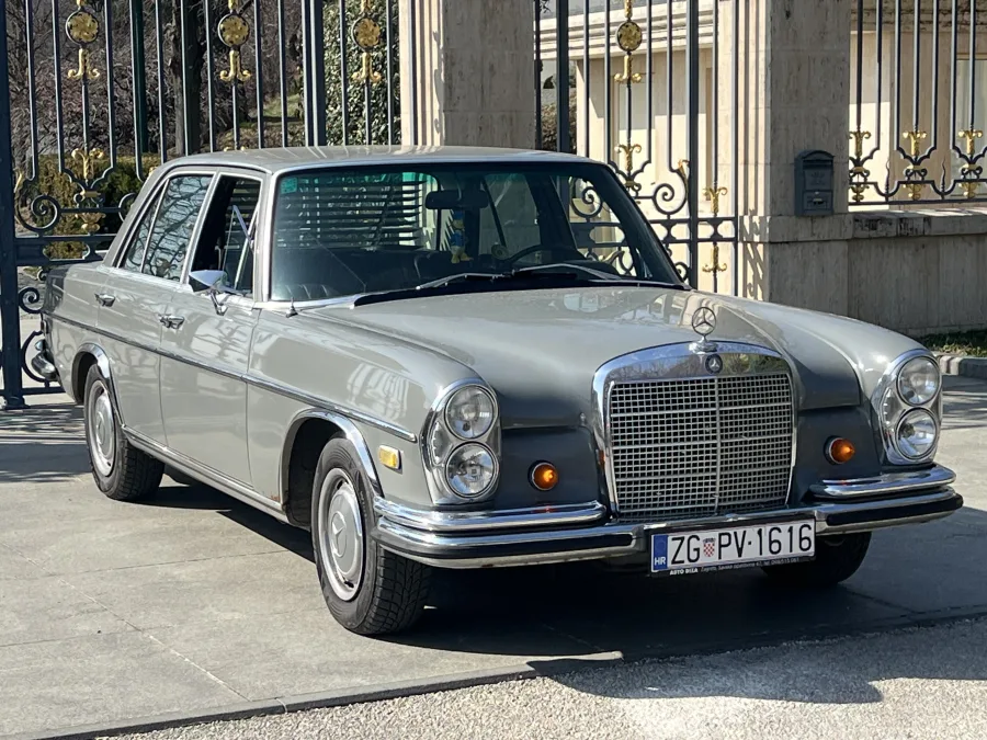 Bočni profil sivog klasičnog Mercedesa iz 1967. godine dostupnog za najam.