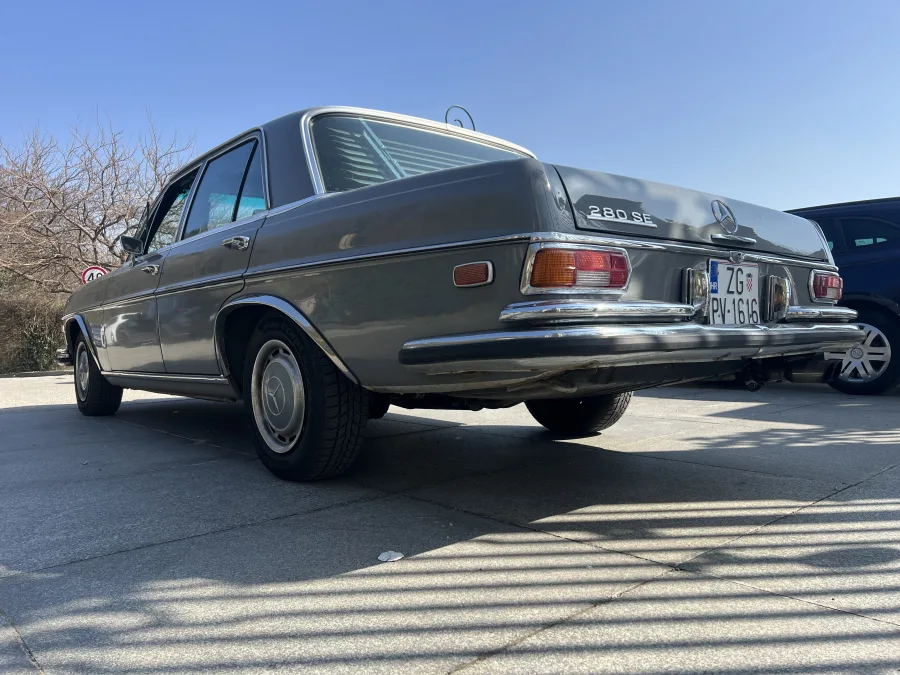 Sivi Mercedes Oldtimer iz 1967., fotografiran s donje strane, za najam za evente.