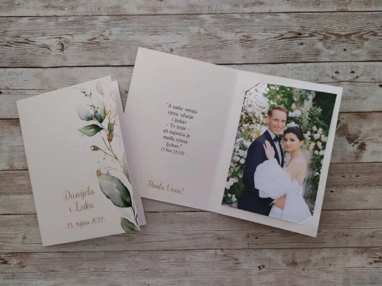 Zahvalnica za vjenčanja s prikazom fotografije mladenaca i njihovom porukom za goste. Na poleđini su njihova imena i datum vjenčanja, a s desne strane se proteže cvijet blijedih boja u akvarel stilu.