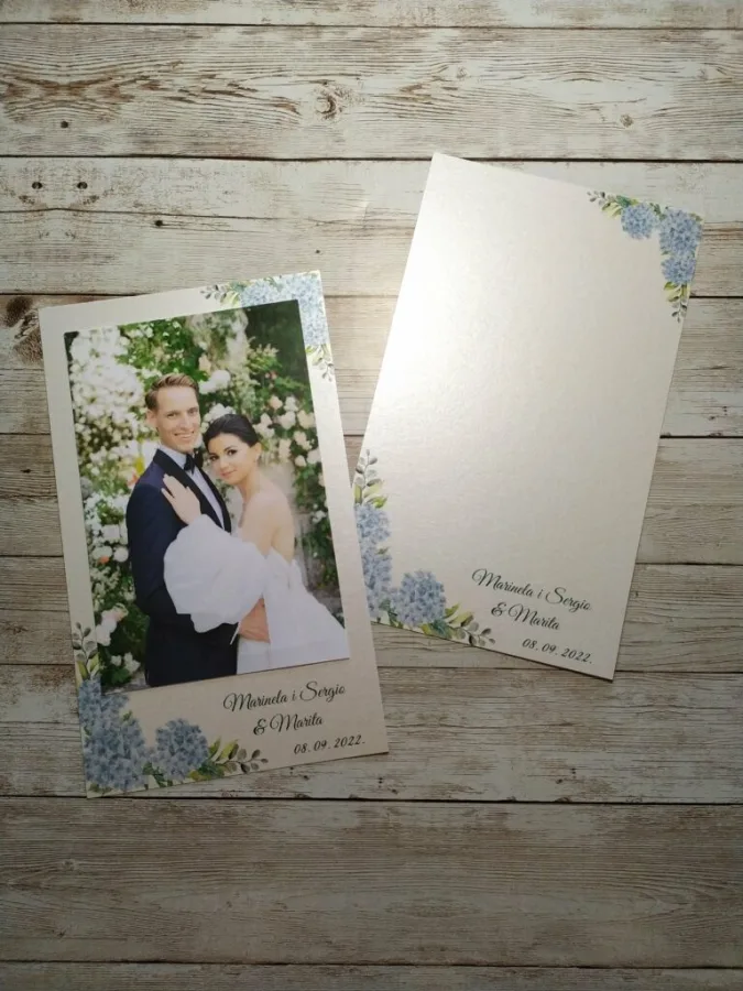 Zahvalnica za vjenčanje fotografijom mladenaca, njihovim imenima i datumom. U rubovima fotografija je dizajn plavih hortenzija.