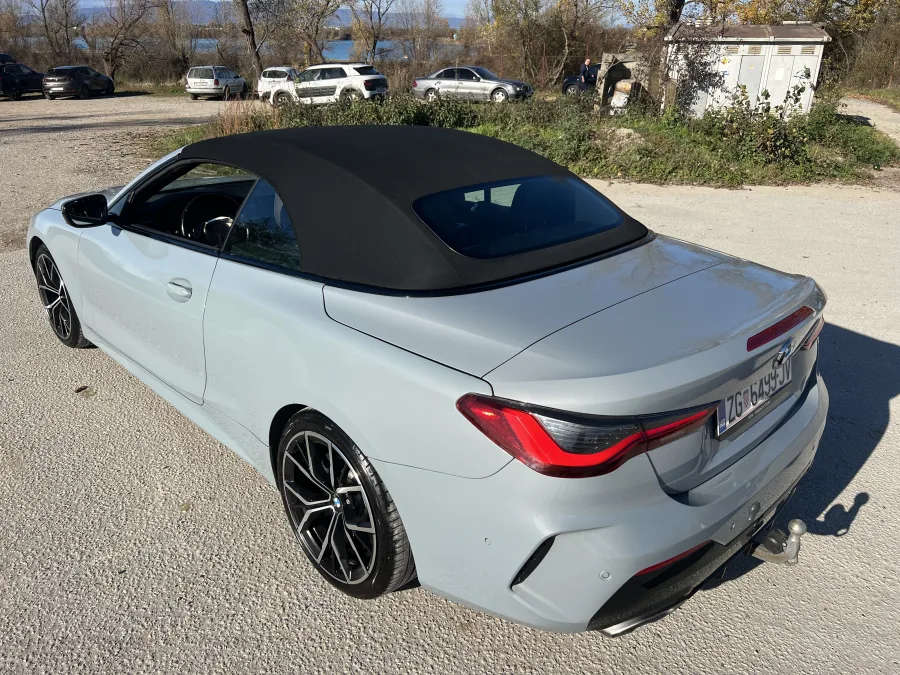 Pogled s stražnjeg boka na moderni plavkasto srebrni BMW Cabrio, luksuzan izbor za ljetne svadbene svečanosti.