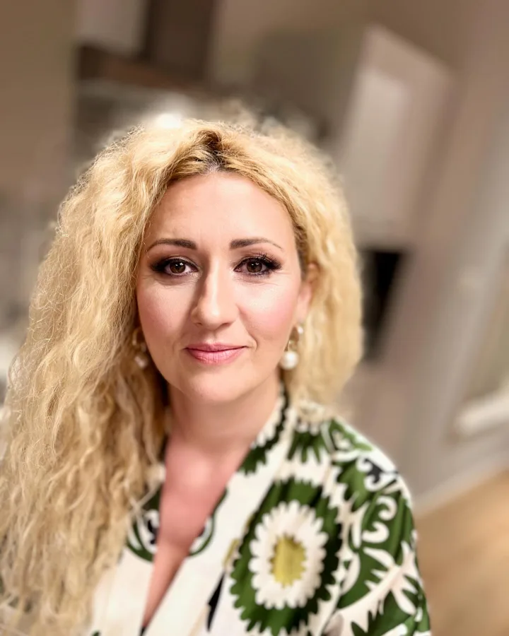 Žena našminkana jednostavnom s umjetnim trepavicama i ružičastim rumenilom.