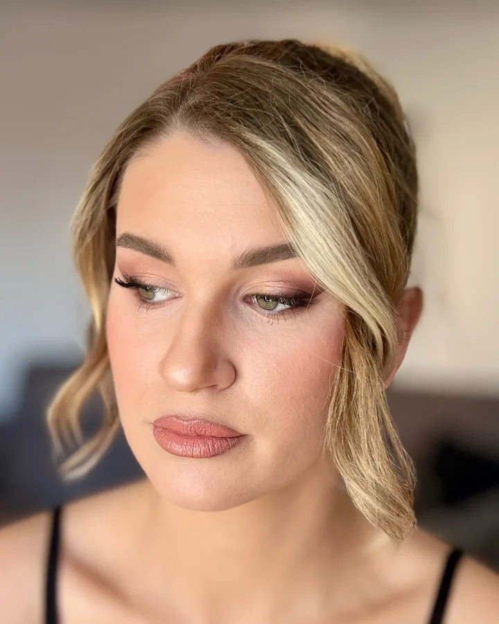 Svečano našminkana djevojke neutralno smeđe palete sjenila s umjetnim trepavicama i smeđo-bež ružom za usne.