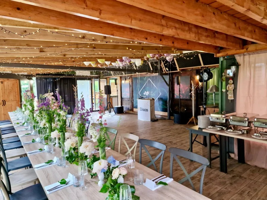 Manja dvorana za proslave s velikim stolom za uzvanike i plesnim podijem.